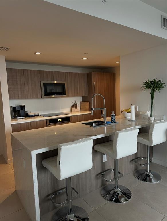 401 North Birch Road, Unit 1212 Fort Lauderdale, FL 33304 - Photo 5 of 40 a kitchen with a sink cabinets and microwave