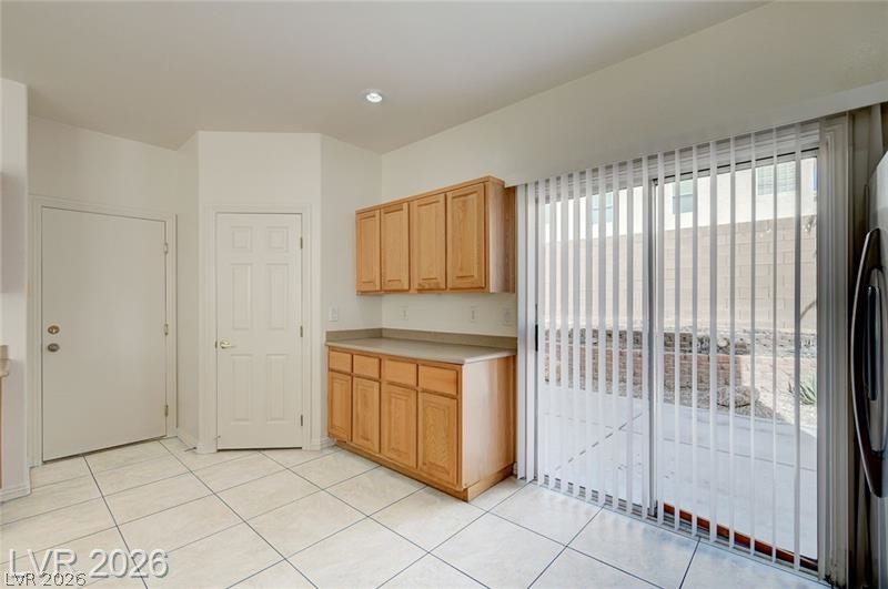 8918 Houston Ridge Avenue Las Vegas, NV 89178 - Photo 10 of 47 Kitchen with light countertops, light tile patterned floors, and stainless steel refrigerator