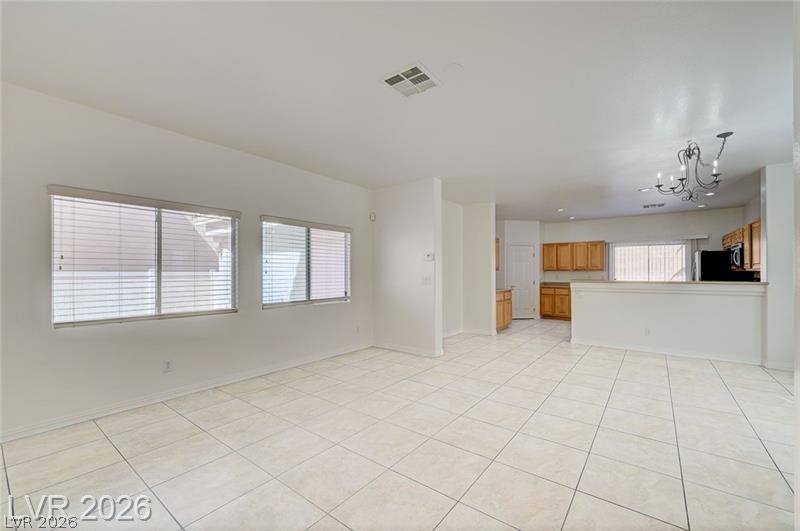8918 Houston Ridge Avenue Las Vegas, NV 89178 - Photo 3 of 47 Unfurnished living room with a chandelier and light tile patterned floors
