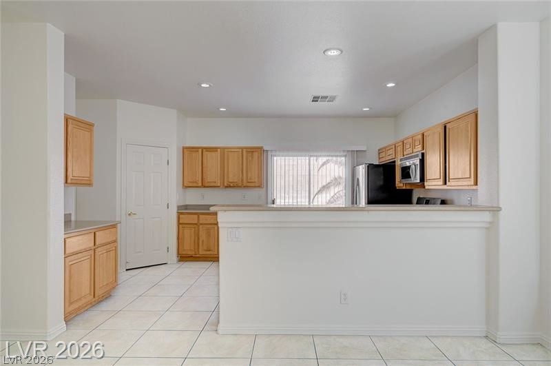 8918 Houston Ridge Avenue Las Vegas, NV 89178 - Photo 7 of 47 Kitchen featuring light countertops, stainless steel appliances, light tile patterned floors, recessed lighting, and a peninsula