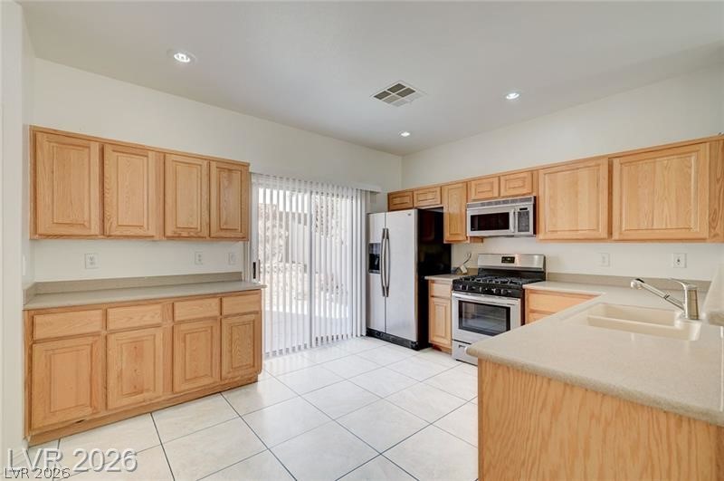 8918 Houston Ridge Avenue Las Vegas, NV 89178 - Photo 8 of 47 Kitchen with stainless steel appliances, light countertops, light wood finish cabinetry, light tile patterned flooring, and recessed lighting