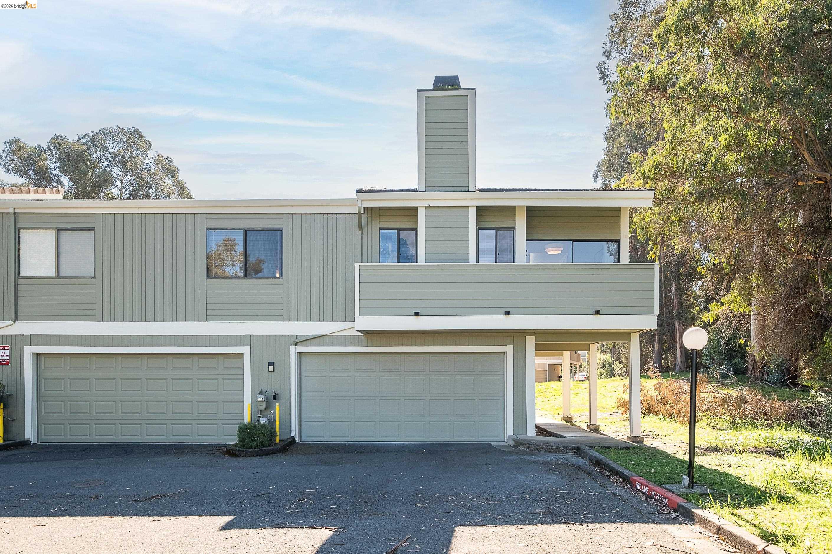 214 Apollo, Unit 3 Hercules, CA 94547 - Photo 21 of 26 View of front of house featuring a balcony, a garage, a chimney, and asphalt driveway