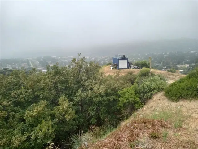 a view of a dry yard with mountains in the background