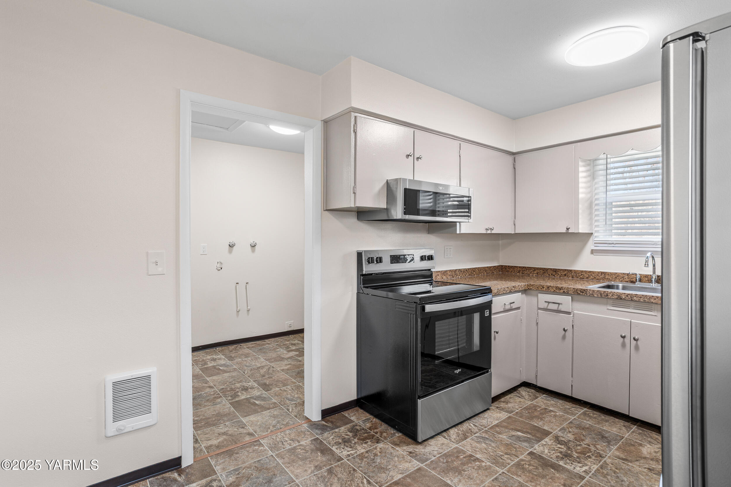 814 Adams Avenue Toppenish, WA 98948 - Photo 4 of 23 a kitchen with stainless steel appliances granite countertop a stove a sink and a refrigerator