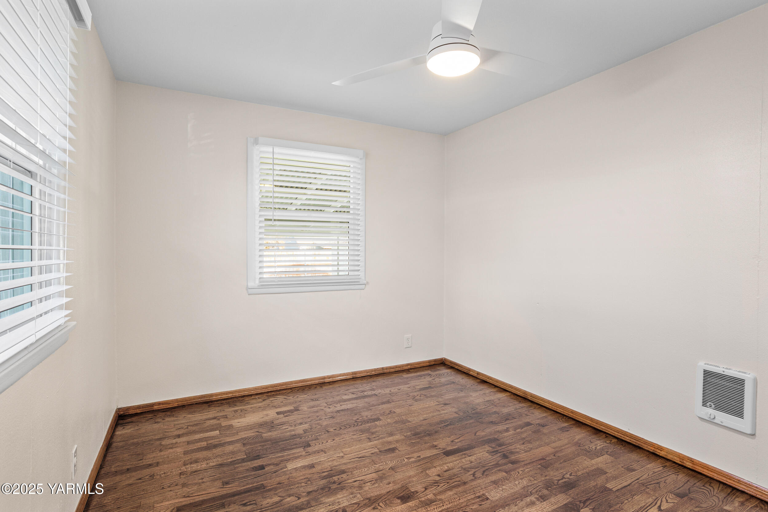 814 Adams Avenue Toppenish, WA 98948 - Photo 8 of 23 an empty room with wooden floor and windows