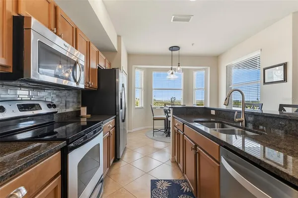 a kitchen with stainless steel appliances granite countertop a sink stove and refrigerator