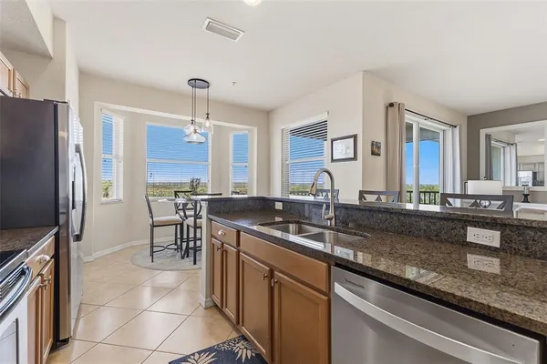 a kitchen with granite countertop a sink and a refrigerator