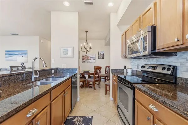 a kitchen with stainless steel appliances granite countertop a sink stove and cabinets