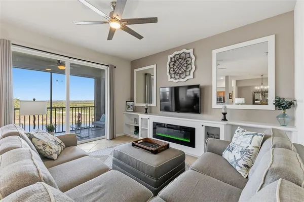 a living room with furniture a flat screen tv and a fireplace
