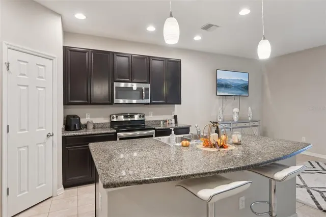 a kitchen with stainless steel appliances granite countertop a sink refrigerator and microwave