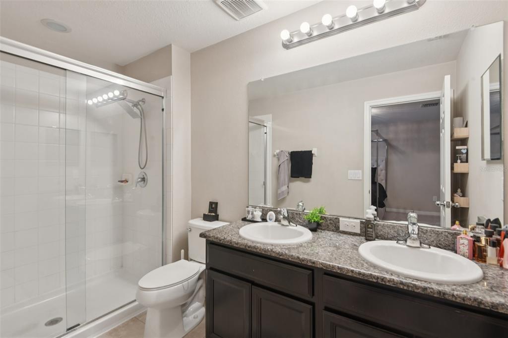 7046 Towne Lake Road Riverview, FL 33578 - Photo 22 of 47 a bathroom with a double vanity sink toilet mirror and shower