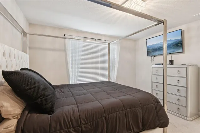 a bedroom with a bed and a flat tv screen on a dresser
