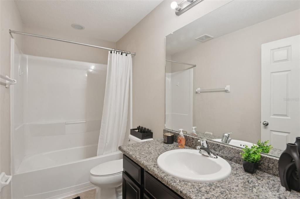7046 Towne Lake Road Riverview, FL 33578 - Photo 26 of 47 a bathroom with a granite countertop sink toilet a mirror and shower