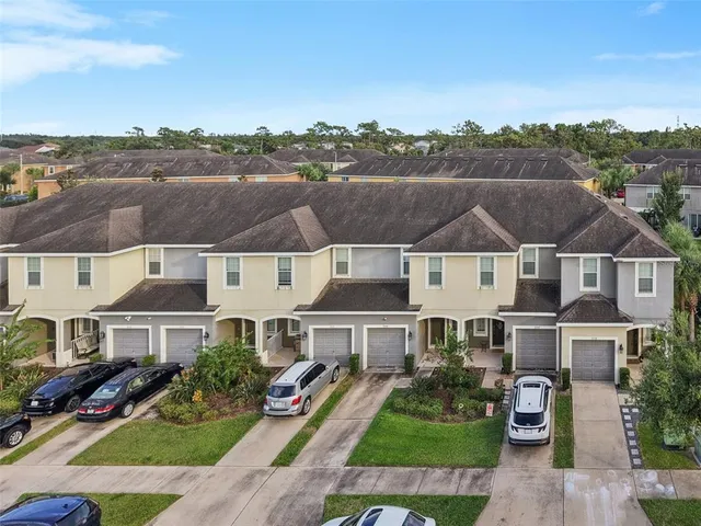 an aerial view of multiple houses with a yard