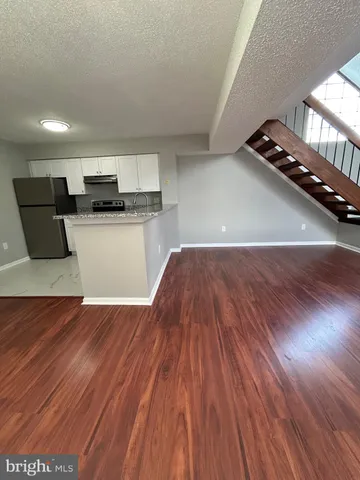 a living room with hard wood floors and a couch