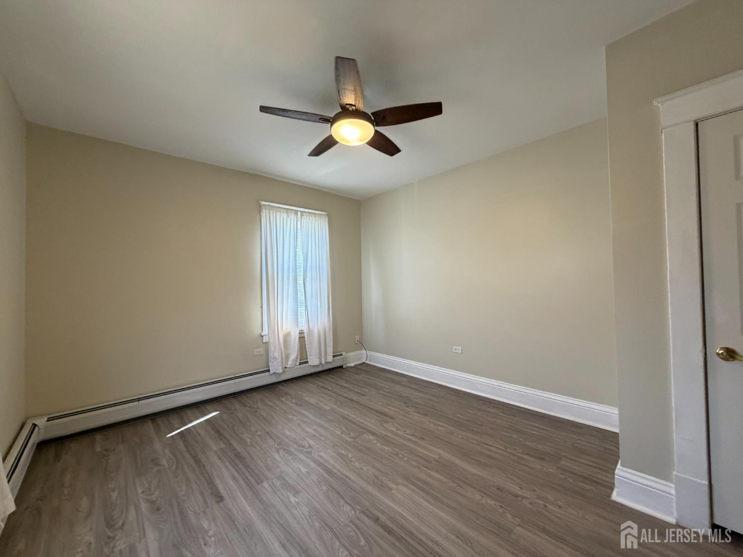 628 Grove Avenue Edison, NJ 08820 - Photo 13 of 21 an empty room with wooden floor ceiling fan and window