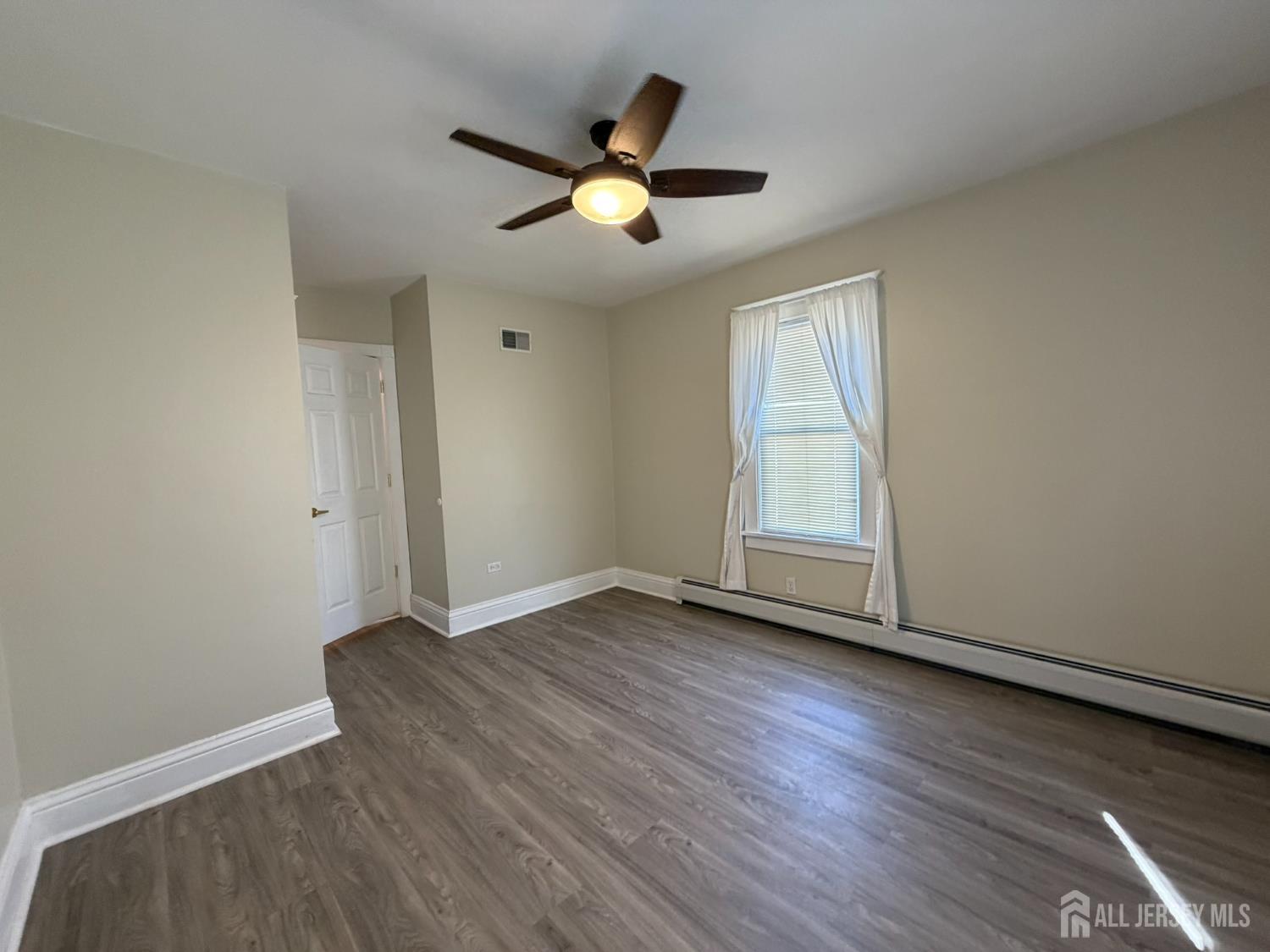 628 Grove Avenue Edison, NJ 08820 - Photo 14 of 21 an empty room with wooden floor and windows
