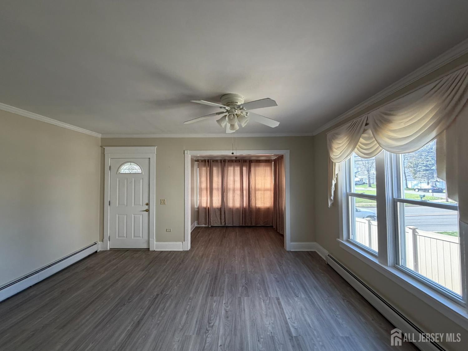 628 Grove Avenue Edison, NJ 08820 - Photo 5 of 21 a view of an empty room with a window and wooden floor