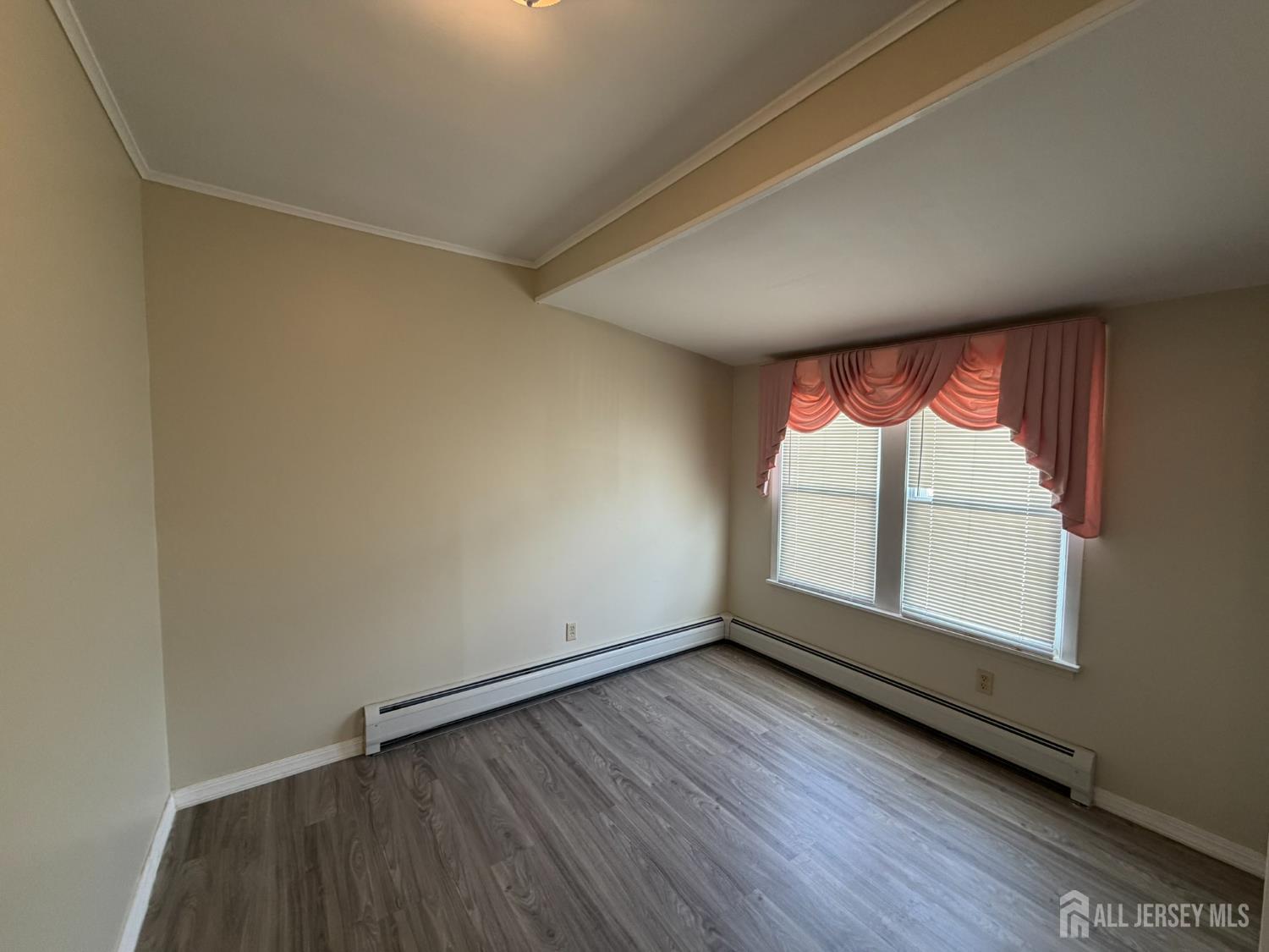 628 Grove Avenue Edison, NJ 08820 - Photo 8 of 21 an empty room with wooden floor and windows