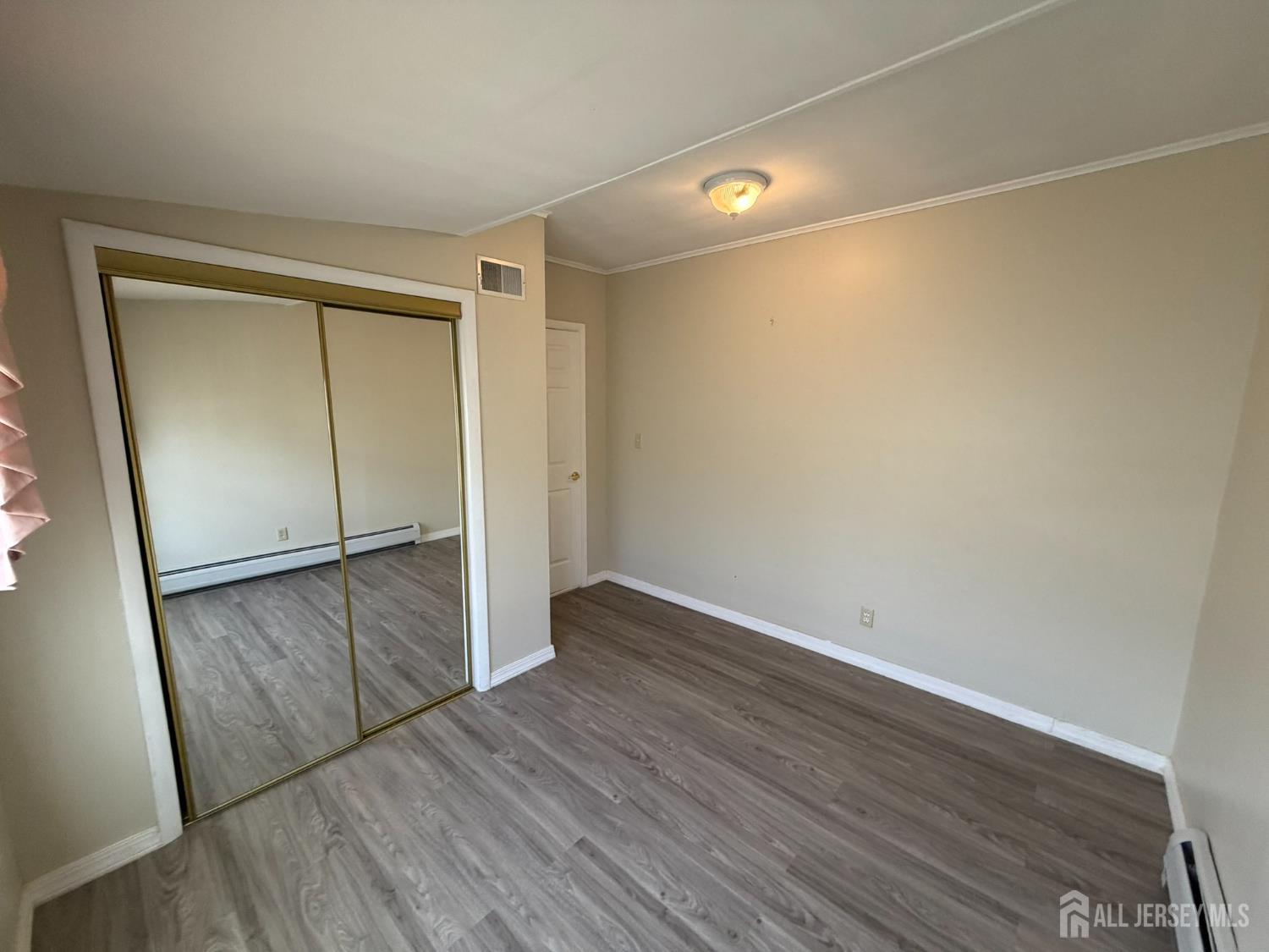 628 Grove Avenue Edison, NJ 08820 - Photo 9 of 21 an empty room with wooden floor