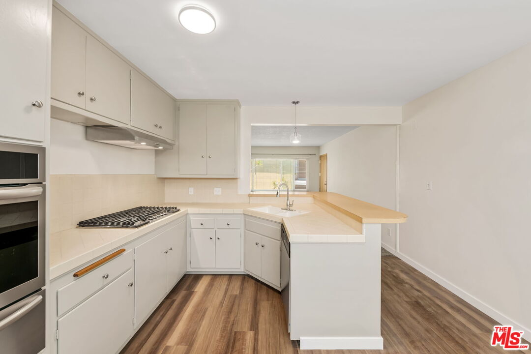 8335 West Manchester Avenue, Unit D Playa del Rey, CA 90293 - Photo 10 of 17 a kitchen with granite countertop a sink a stove and cabinets