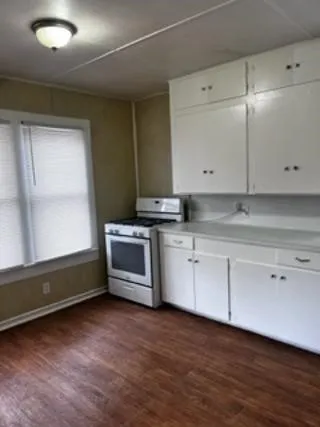 a kitchen with granite countertop white cabinets and white appliances