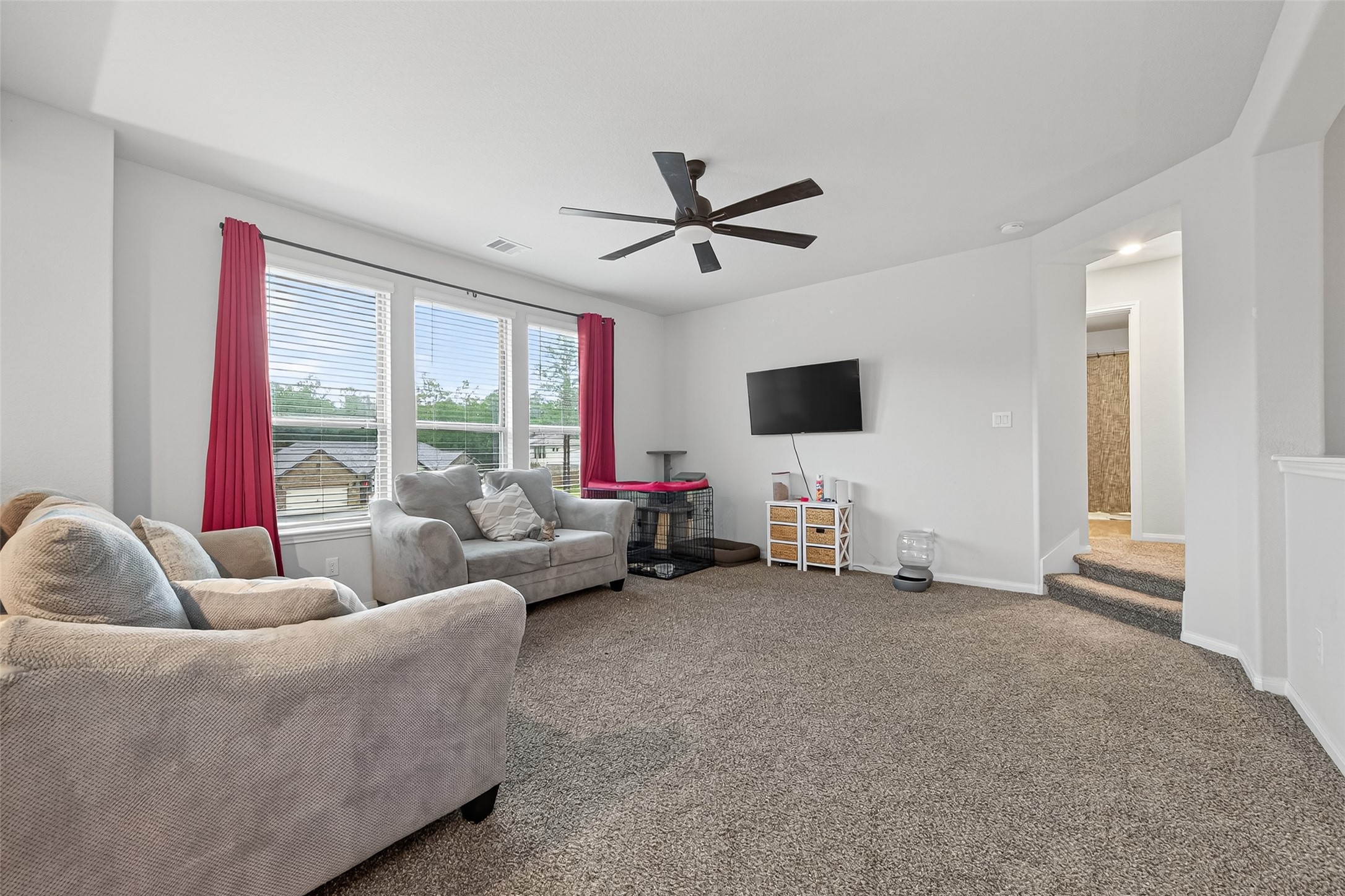 16601 Crosby Street Conroe, TX 77303 - Photo 37 of 50 Spacious upstairs game room featuring plush carpeting, abundant natural light, and plenty of room for lounging, entertaining, or a second living area.