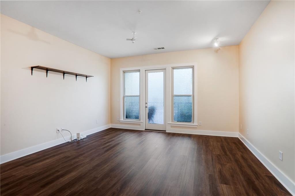 1195 Milton Terrace Southeast, Unit 2203 Atlanta, GA 30315 - Photo 4 of 16 an empty room with wooden floor and windows