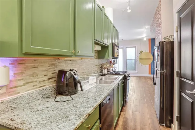 a kitchen with stainless steel appliances granite countertop a stove a sink and a refrigerator