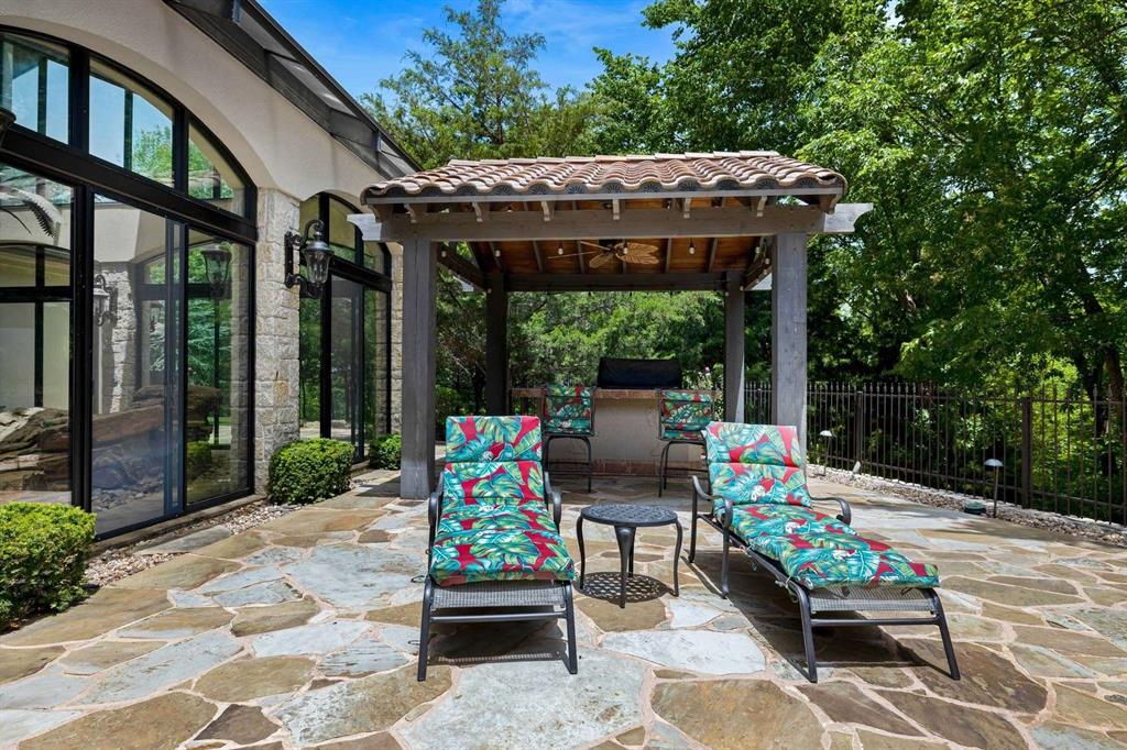 2115 Paradise Rnch Trail McKinney, TX 75071 - Photo 31 of 40 Stone patio featuring a covered outdoor kitchen area with a built-in grill, tile roof, and ceiling fan