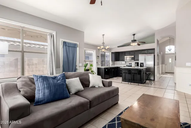 a living room with furniture kitchen view and a window