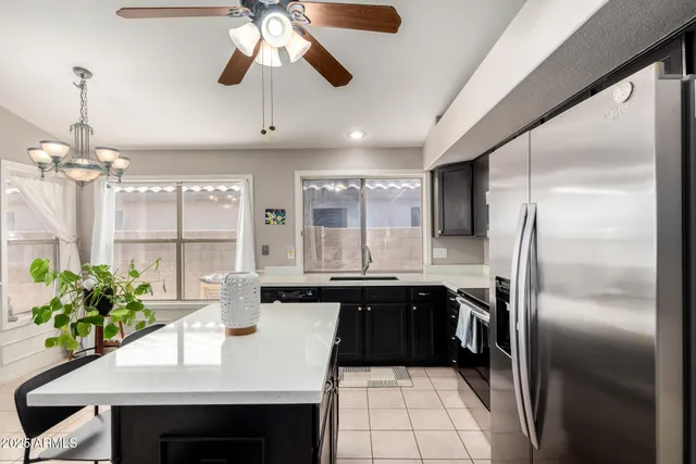 a kitchen with kitchen island a counter space a sink appliances and cabinets