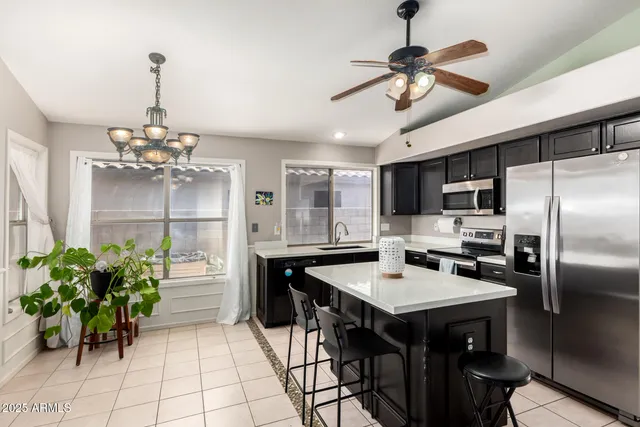 a kitchen with granite countertop a table chairs stainless steel appliances and cabinets