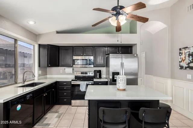 a kitchen with stainless steel appliances a sink counter space cabinets and furniture