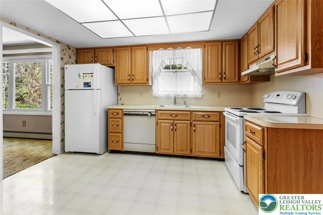 a kitchen with stainless steel appliances granite countertop a stove a sink dishwasher and a refrigerator with wooden cabinets