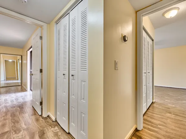 a view of a hallway with wooden floor and staircase
