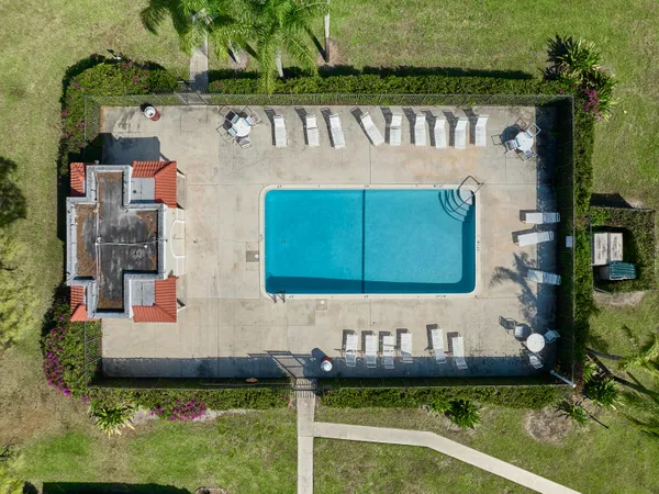 a front view of a house with a garden and swimming pool