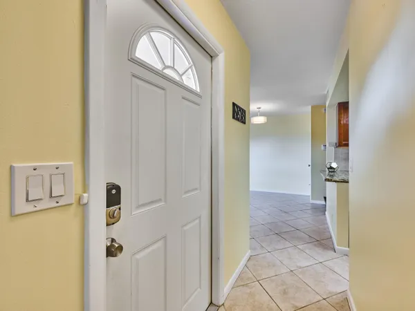 a view of a hallway with wooden floor and a bathroom