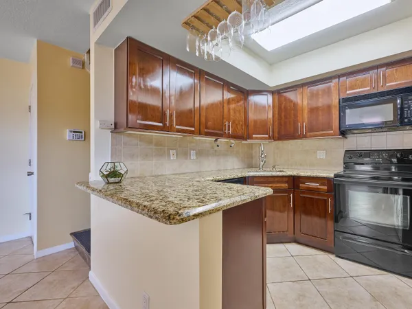 a kitchen with stainless steel appliances granite countertop a sink stove and cabinets