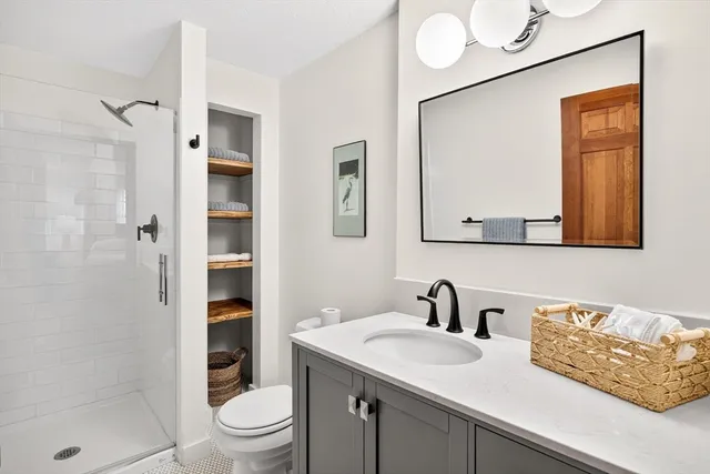 a bathroom with a sink a toilet and shower