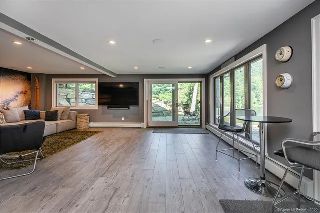 a view of an empty room with wooden floor and windows