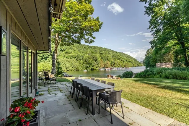 a view of a chairs and table in the patio with a backyard