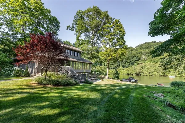 a view of a house with a big yard and large trees