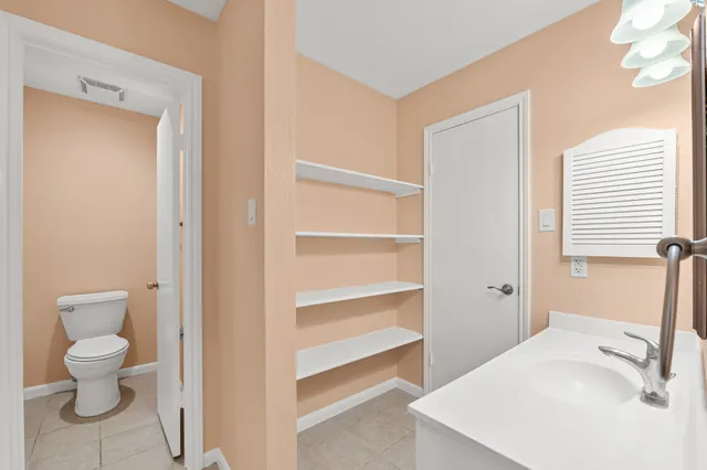 a bathroom with a sink a toilet and a large mirror