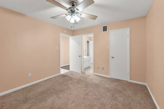 an empty room with chandelier fan
