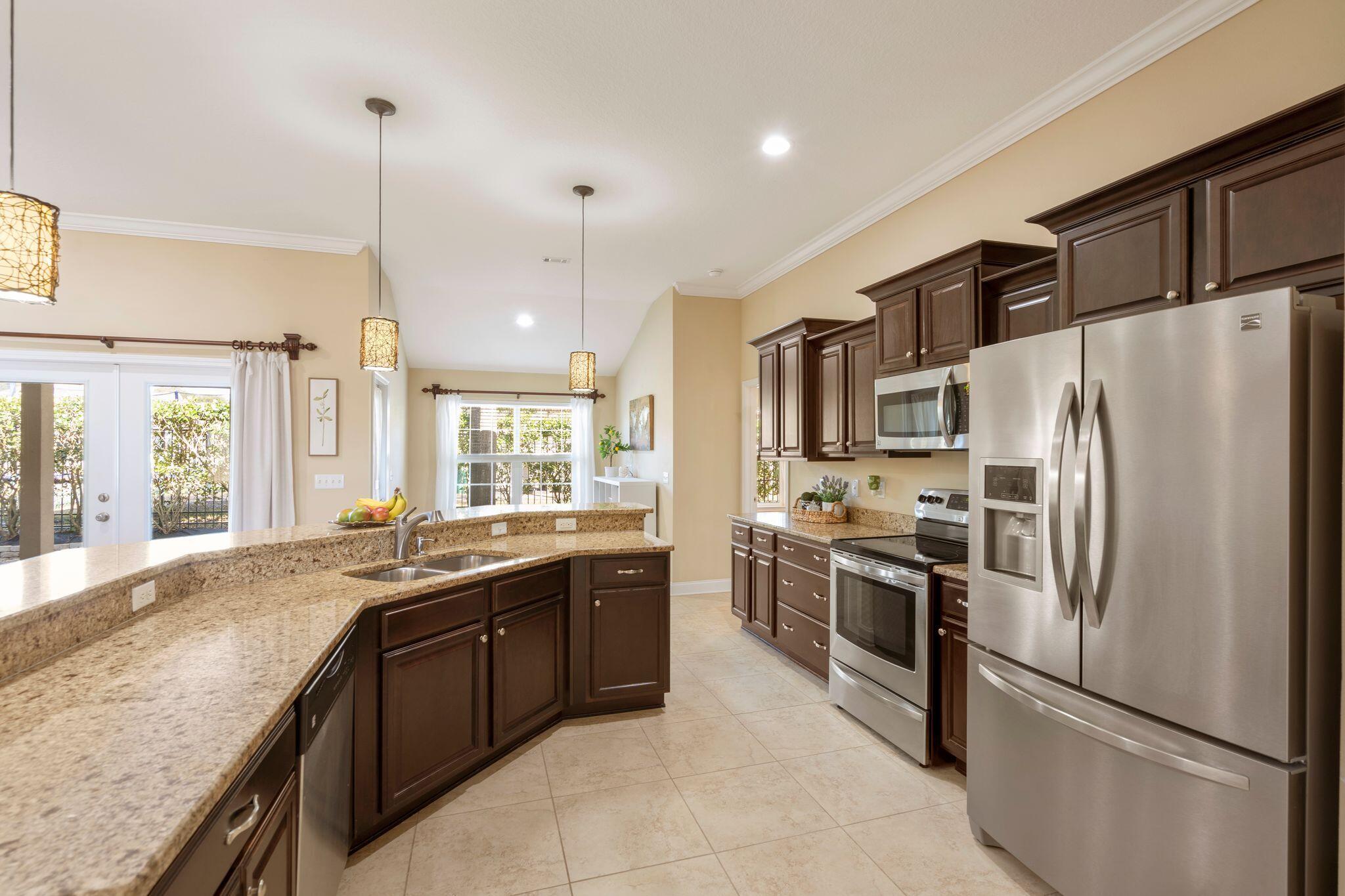 2933 Chancel Avenue Crestview, FL 32539 - Photo 11 of 44 a kitchen with stainless steel appliances granite countertop a refrigerator a sink a stove and a wooden floors