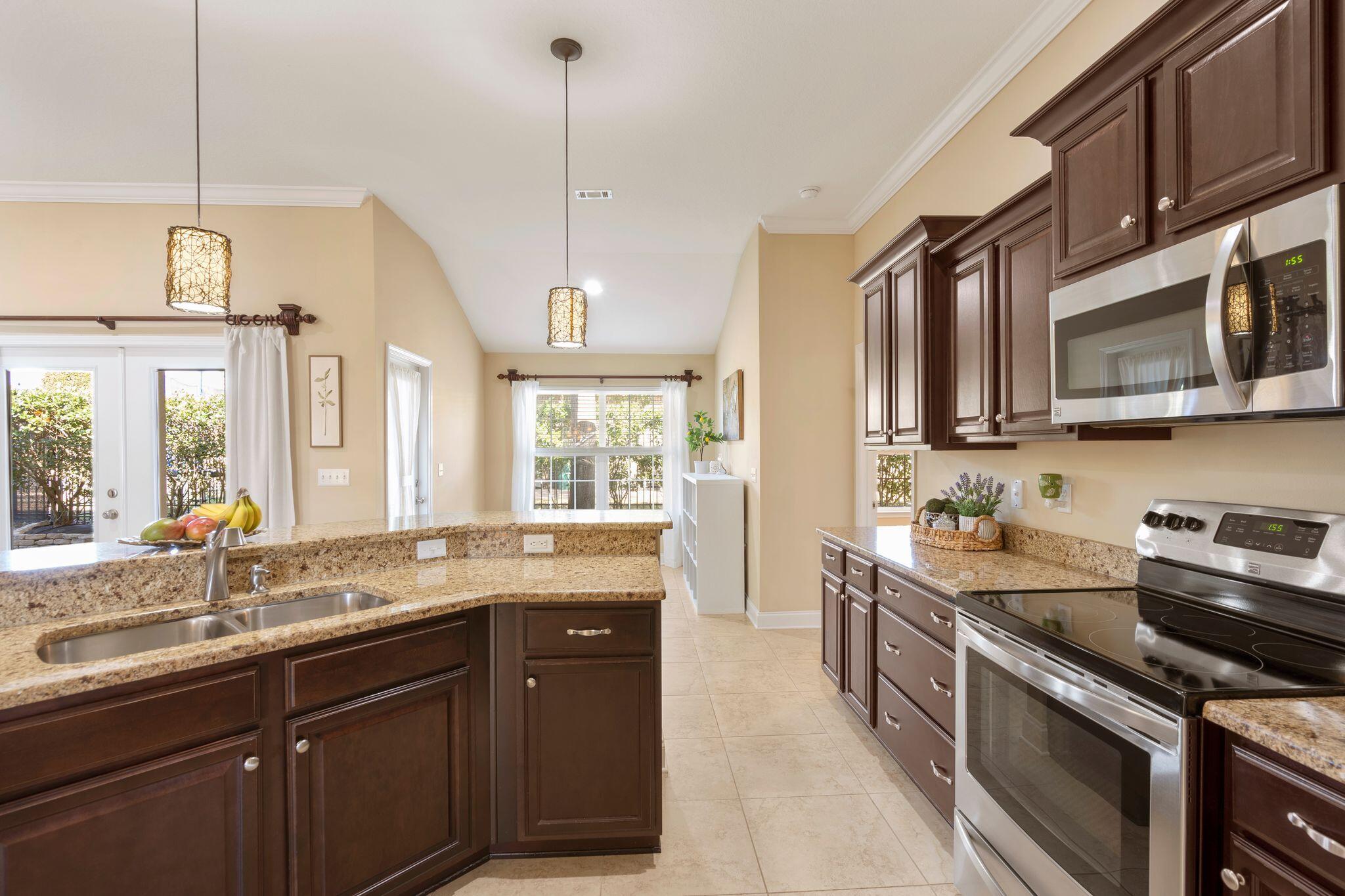 2933 Chancel Avenue Crestview, FL 32539 - Photo 12 of 44 a kitchen with stainless steel appliances granite countertop a sink a stove and a wooden cabinets