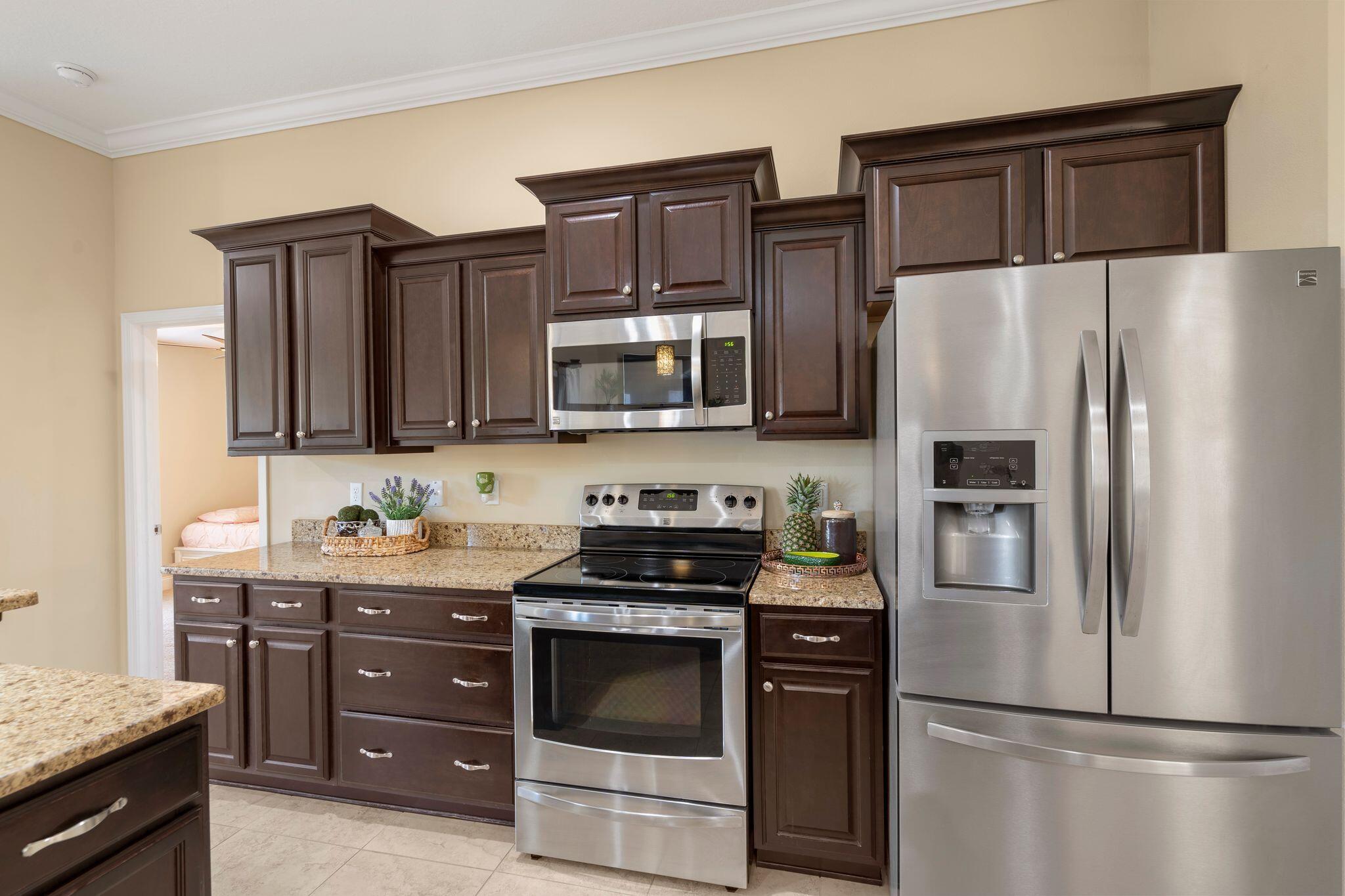 2933 Chancel Avenue Crestview, FL 32539 - Photo 13 of 44 a kitchen with stainless steel appliances granite countertop a refrigerator stove and microwave