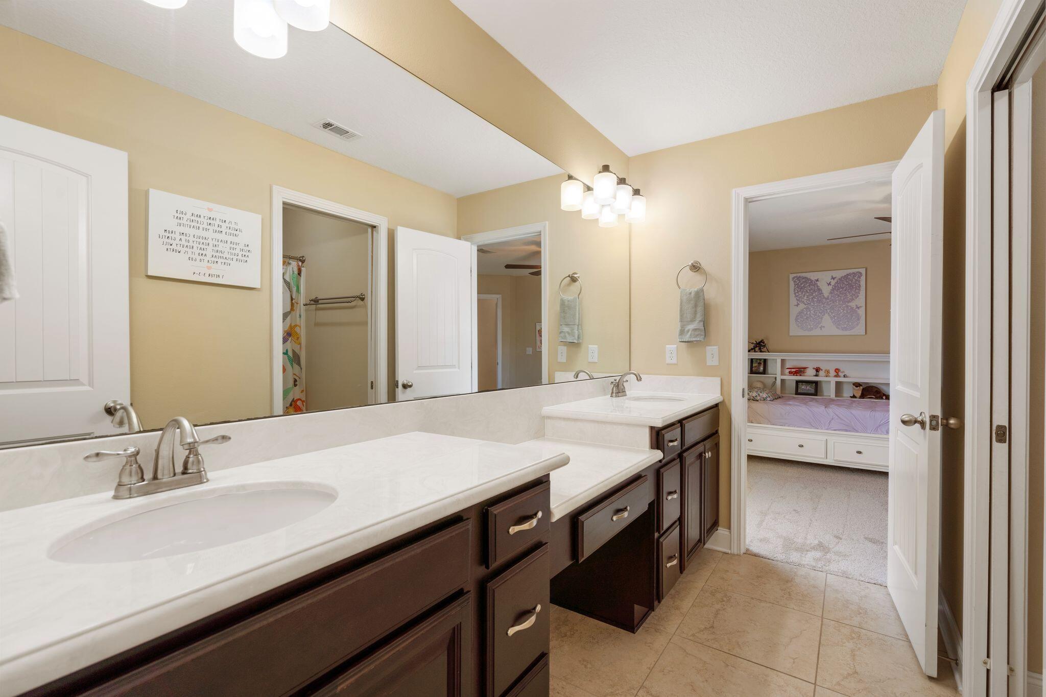 2933 Chancel Avenue Crestview, FL 32539 - Photo 36 of 44 a bathroom with a granite countertop sink a mirror and a bathtub