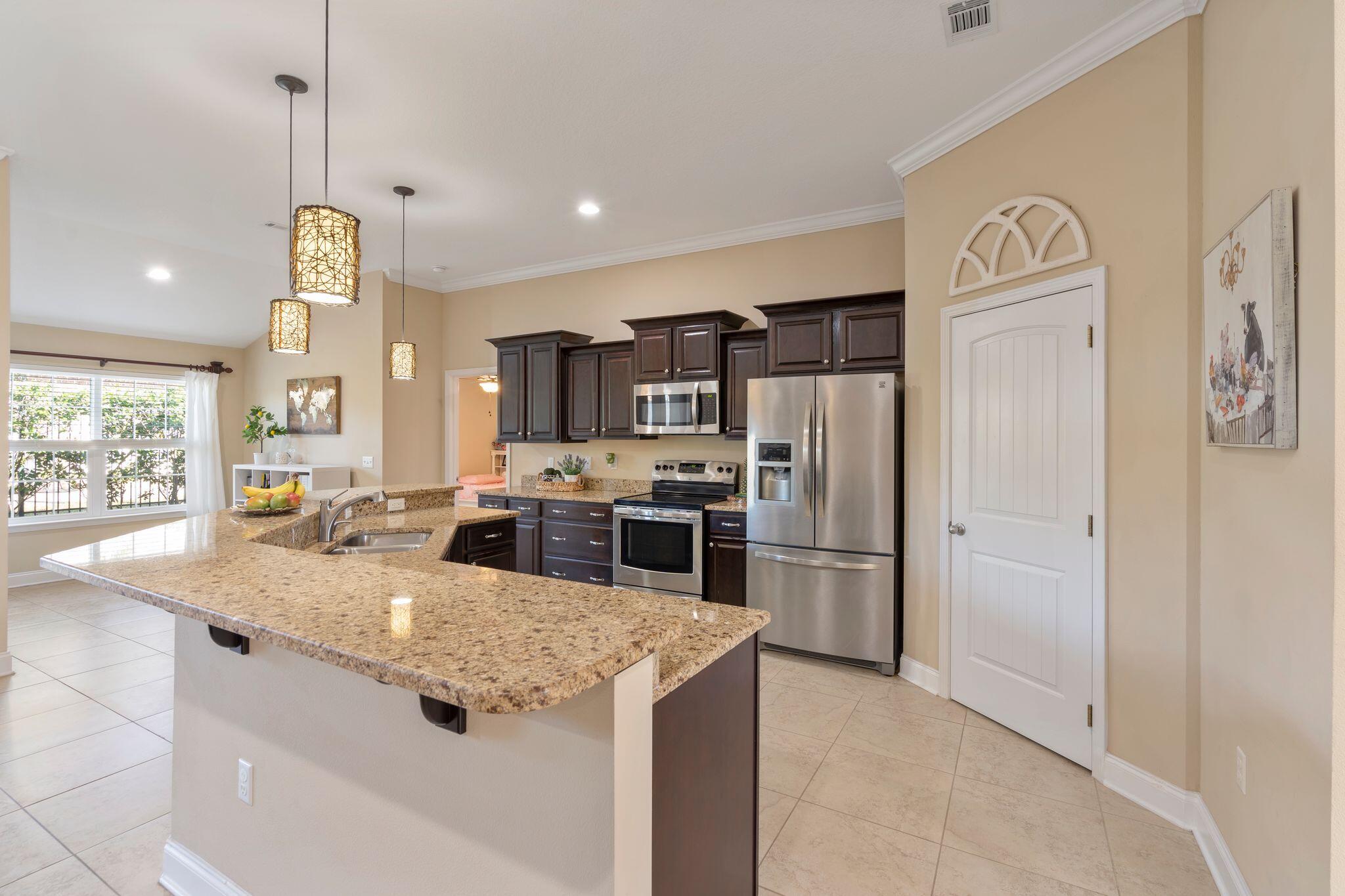 2933 Chancel Avenue Crestview, FL 32539 - Photo 8 of 44 a kitchen with stainless steel appliances granite countertop a sink a stove and a refrigerator